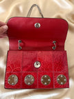 Borsa rossa in coccodrillo con borchie argento e tracolla metallica “Nicolette”