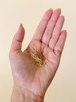 Spilla logo YSL dorata con dust nera “Yves Saint Laurent”