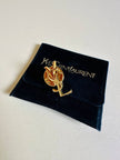 Spilla logo YSL dorata con dust nera “Yves Saint Laurent”