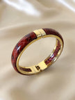 Bracciale vintage rigido in metallo dorato e pelle di serpente rossa