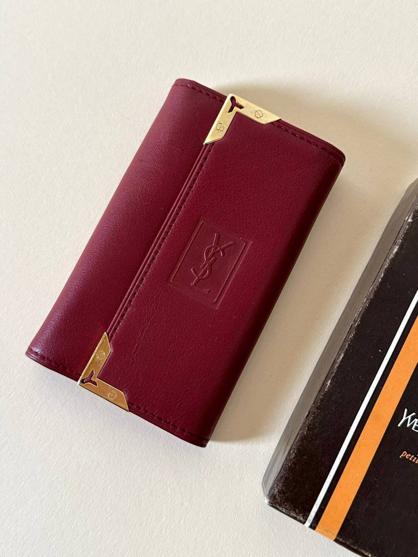 Portachiavi trifold Yves Saint Laurent in pelle rosso granata con dettagli dorati e logo YSL a caldo