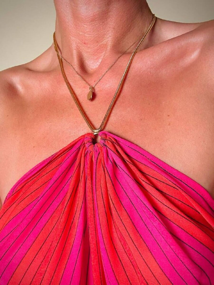 Abito midi a righe nei toni del fucsia e rosso con collana gioiello “Armonie”
