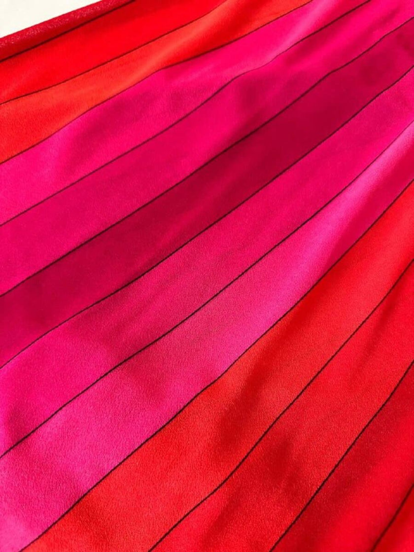 Abito midi a righe nei toni del fucsia e rosso con collana gioiello “Armonie”