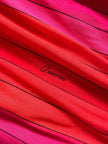Abito midi a righe nei toni del fucsia e rosso con collana gioiello “Armonie”