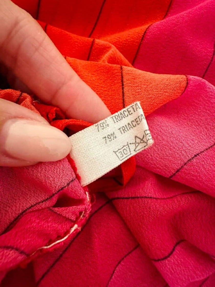 Abito midi a righe nei toni del fucsia e rosso con collana gioiello “Armonie”