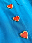 Blazer in shantung turchese con bottoni rossi a forma di cuore 