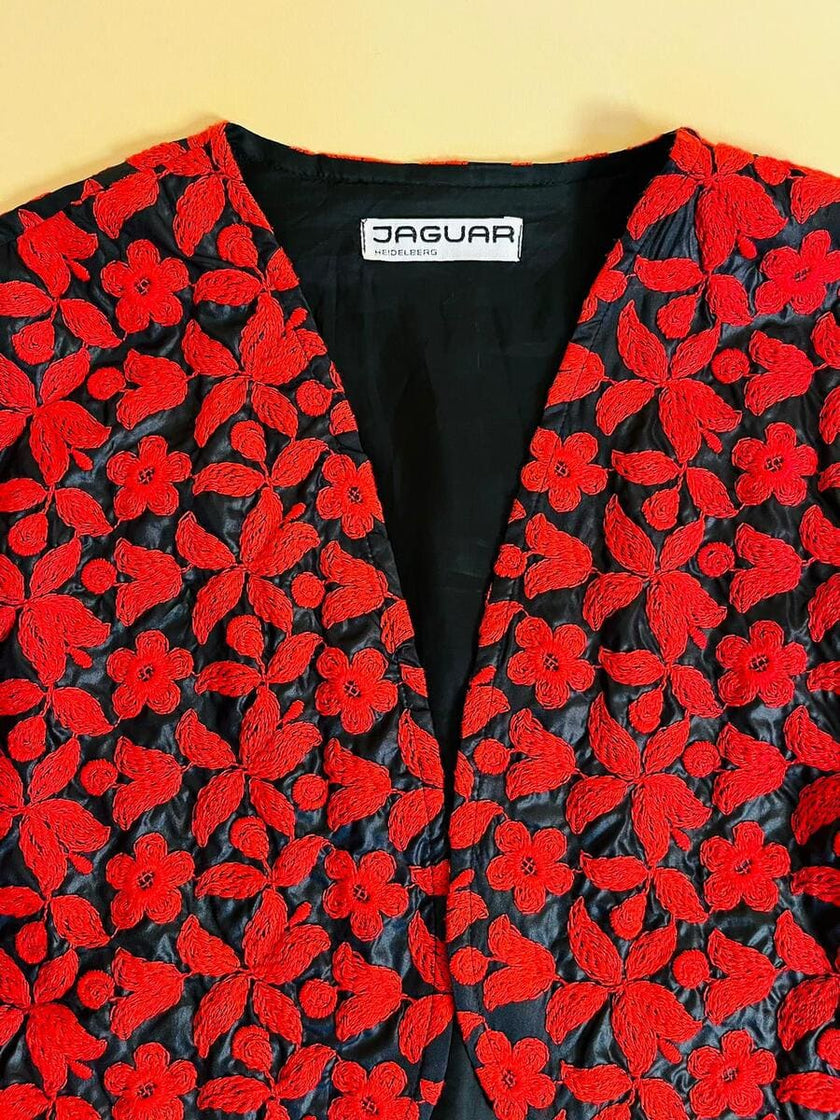 Bolero in tessuto lucido nero con ricamo floreale rosso
