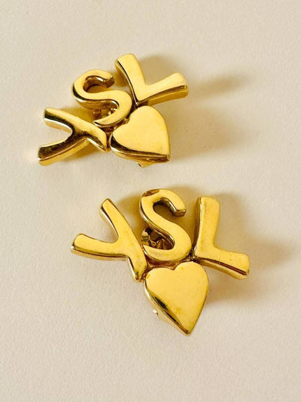 Clip dorate con cuore e iniziali YSL 