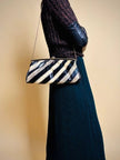 Pochette in whips a righe beige e nere con tracolla in catena oro 