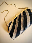 Pochette in whips a righe beige e nere con tracolla in catena oro 