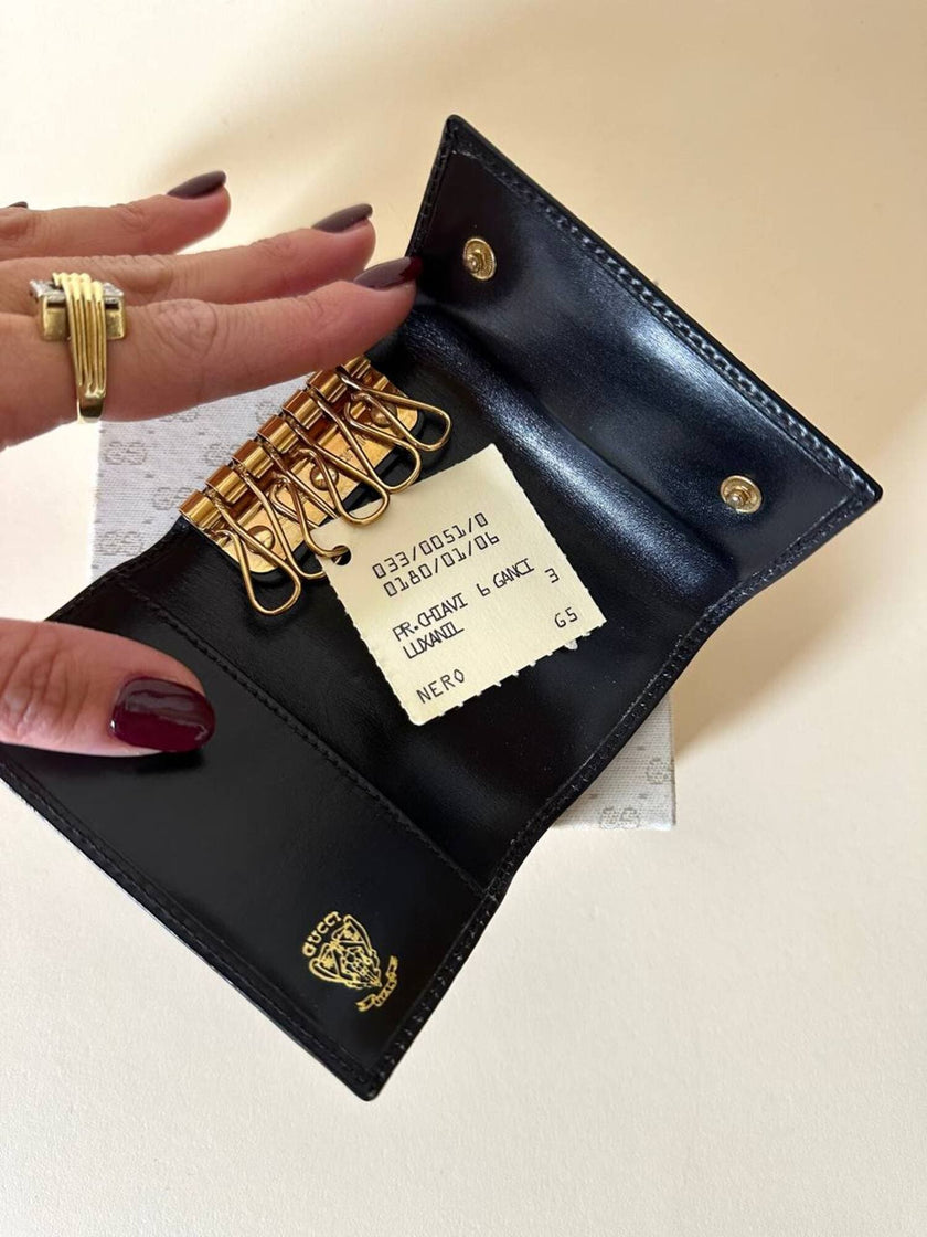 Portachiavi trifold Gucci in pelle nera con logo in metallo oro e scatola originale