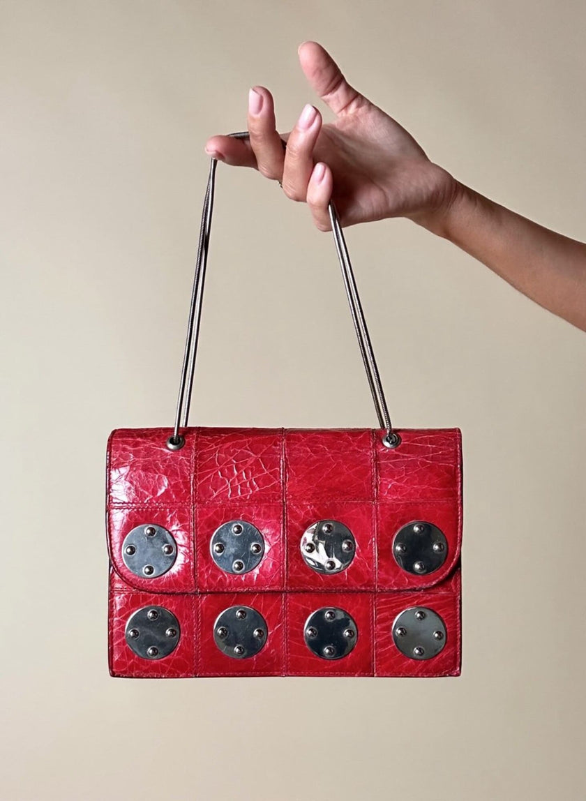 Borsa rossa in coccodrillo con borchie argento e tracolla metallica “Nicolette”