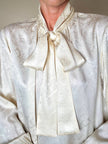 Blusa Yves Saint Laurent con fiocco al collo in seta jacquard avorio fantasia pitone