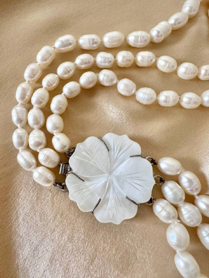 Collana di perle a tre fili con chiusura in madreperla a forma di fiore