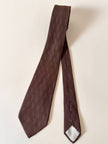 Cravatta Yves Saint Laurent in seta jacquard marrone con logo YSL allover