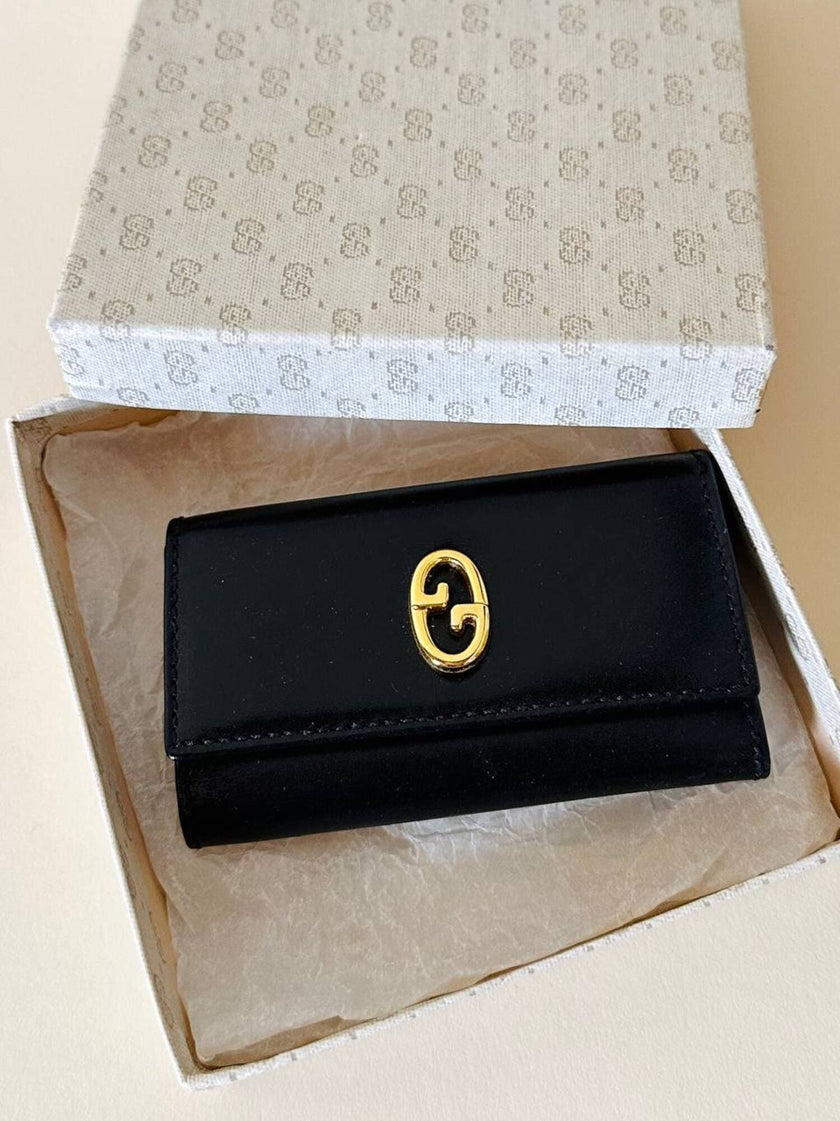 Portachiavi trifold Gucci in pelle nera con logo in metallo oro e scatola originale