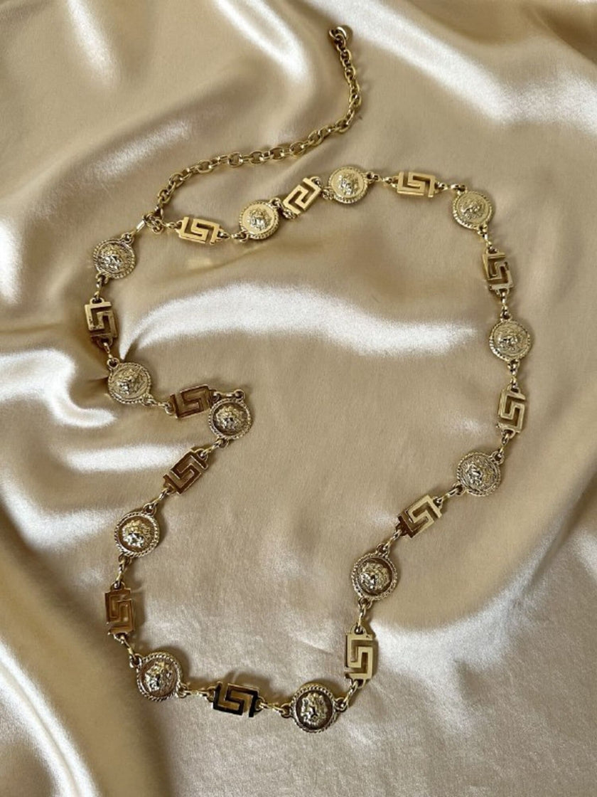 Cintura/collana dorata composta da greche e teste di leone