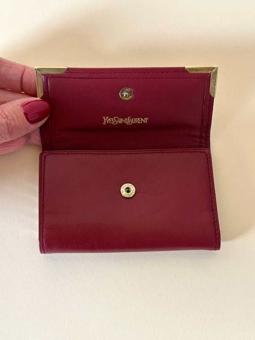 Portachiavi trifold Yves Saint Laurent in pelle rosso granata con dettagli dorati e logo YSL a caldo