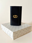 Portachiavi trifold Gucci in pelle nera con logo in metallo oro e scatola originale