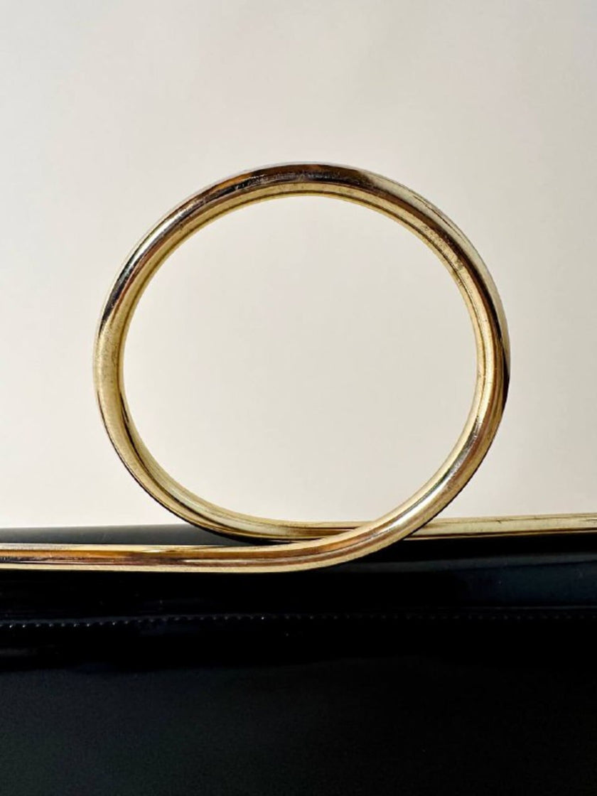 Borsa in vernice nera con manico design in metallo oro