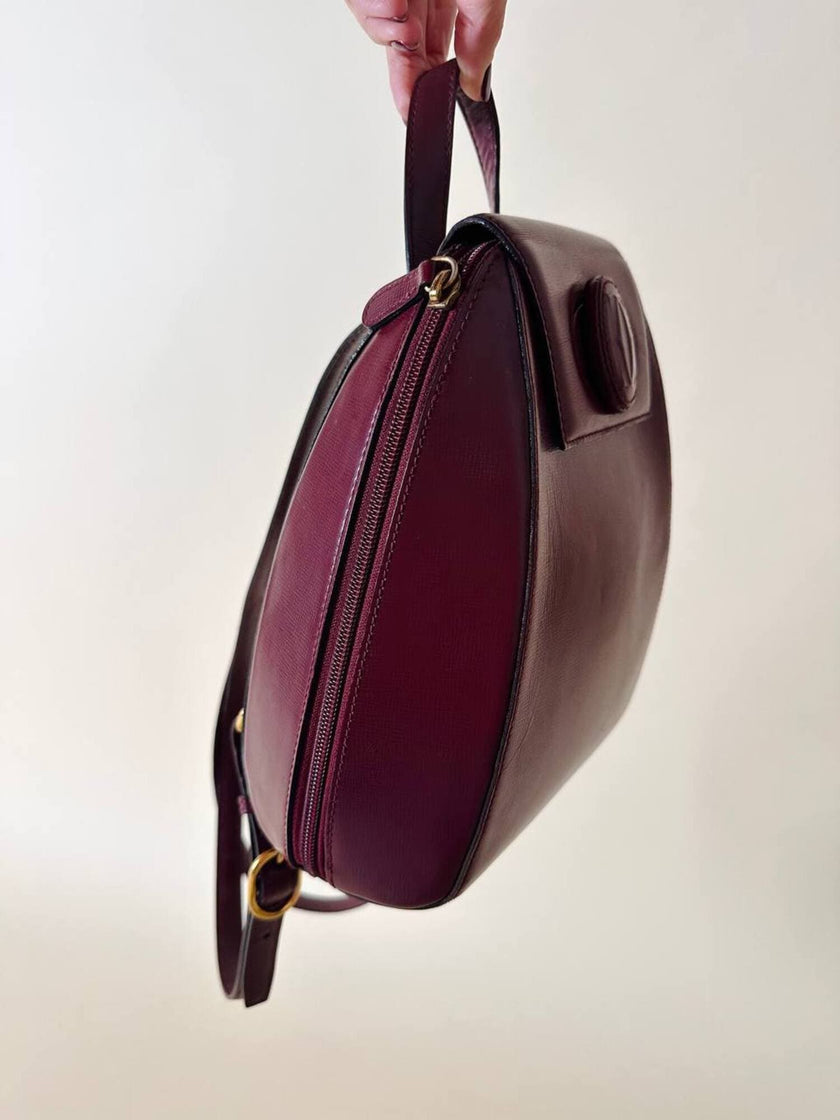 Sac à dos Must de Cartier en cuir bordeaux avec finitions dorées