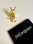 Spilla logo YSL dorata con dust nera “Yves Saint Laurent”