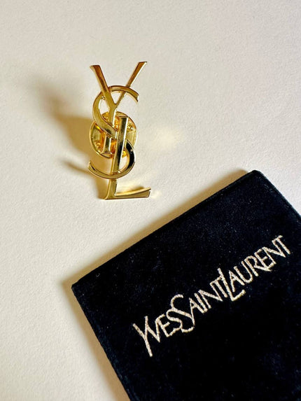 Spilla logo YSL dorata con dust nera “Yves Saint Laurent”