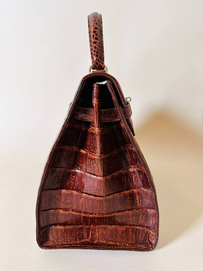 Borsa a trapezio in pelle di coccodrillo color cognac con tracolla e hardware oro Idra