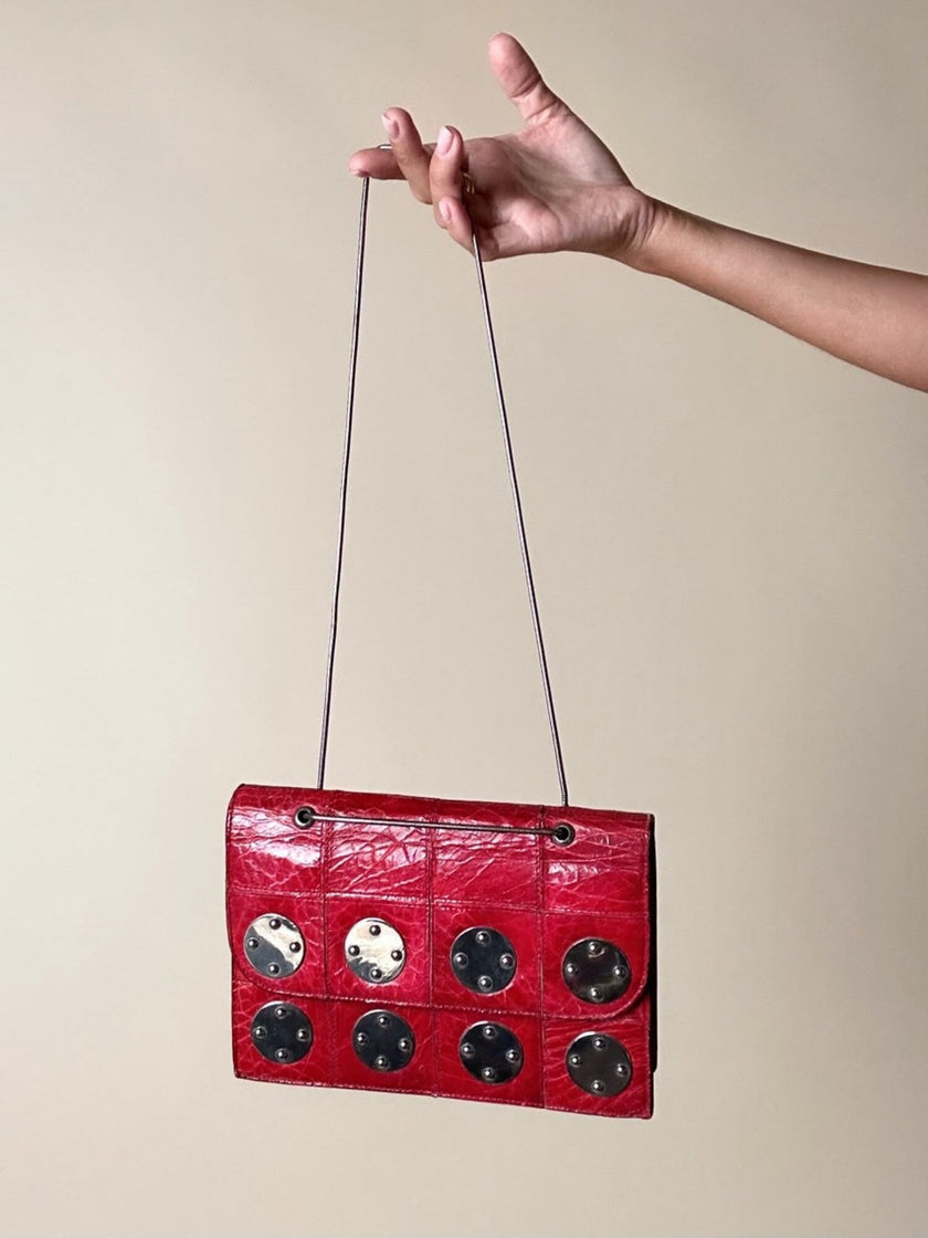 Borsa rossa in coccodrillo con borchie argento e tracolla metallica “Nicolette”