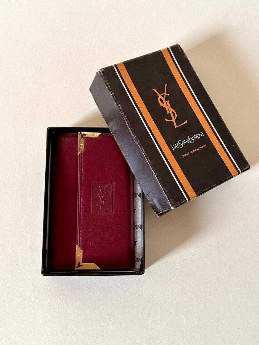 Portachiavi trifold Yves Saint Laurent in pelle rosso granata con dettagli dorati e logo YSL a caldo