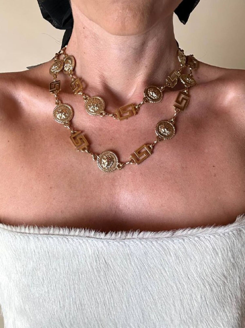 Cintura/collana dorata composta da greche e teste di leone