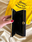 Mini pochette in tessuto nero con chiusura logata color oro “Gucci”