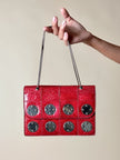 Borsa rossa in coccodrillo con borchie argento e tracolla metallica “Nicolette”