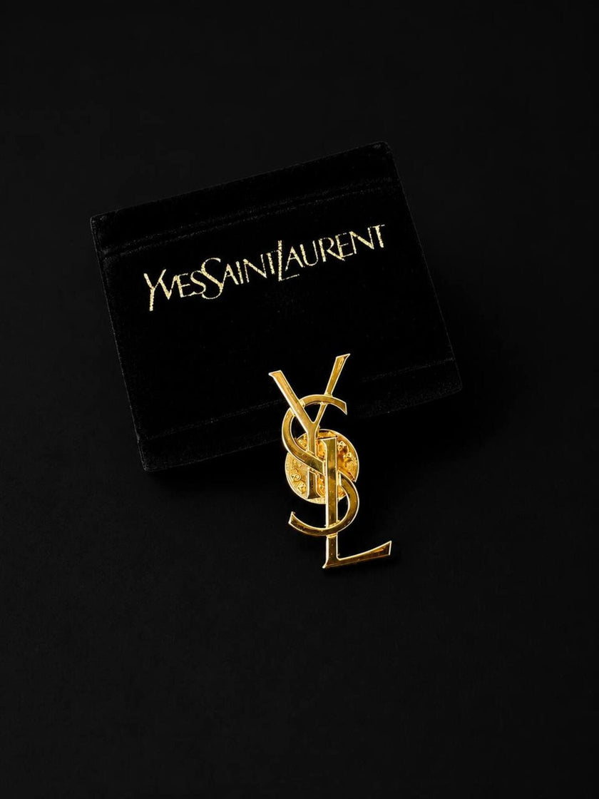 Vintage Yves Saint Laurent logo brooch in gold-tone metal