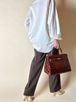Borsa a trapezio in pelle di coccodrillo color cognac con tracolla e hardware oro Idra