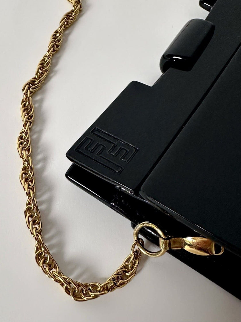Borsa vintage Fendi in lucite nera con logo inciso e tracolla a catena dorata