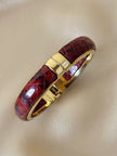 Bracciale vintage rigido in metallo dorato e pelle di serpente rossa