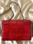 Borsa rossa in coccodrillo con borchie argento e tracolla metallica “Nicolette”