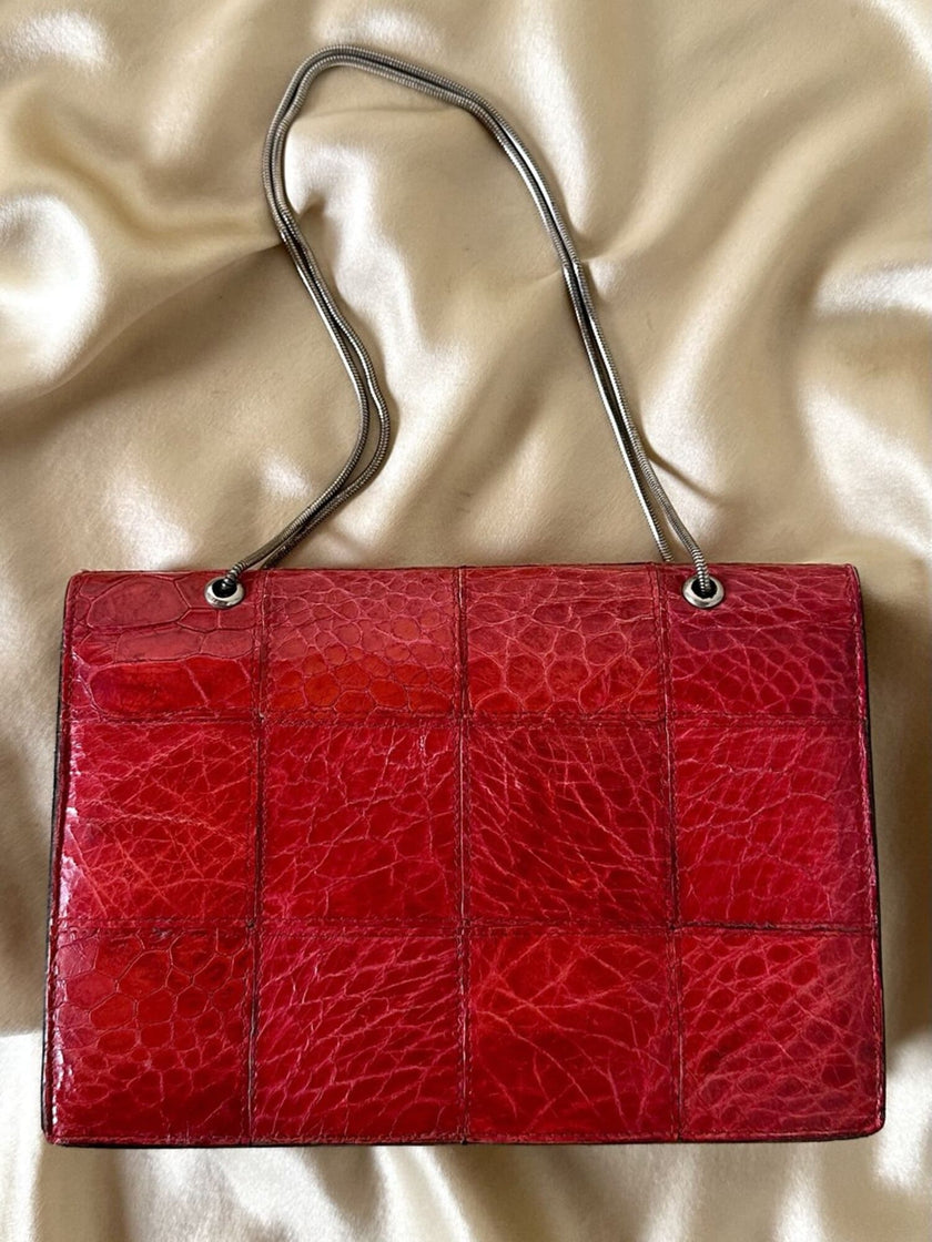 Borsa rossa in coccodrillo con borchie argento e tracolla metallica “Nicolette”