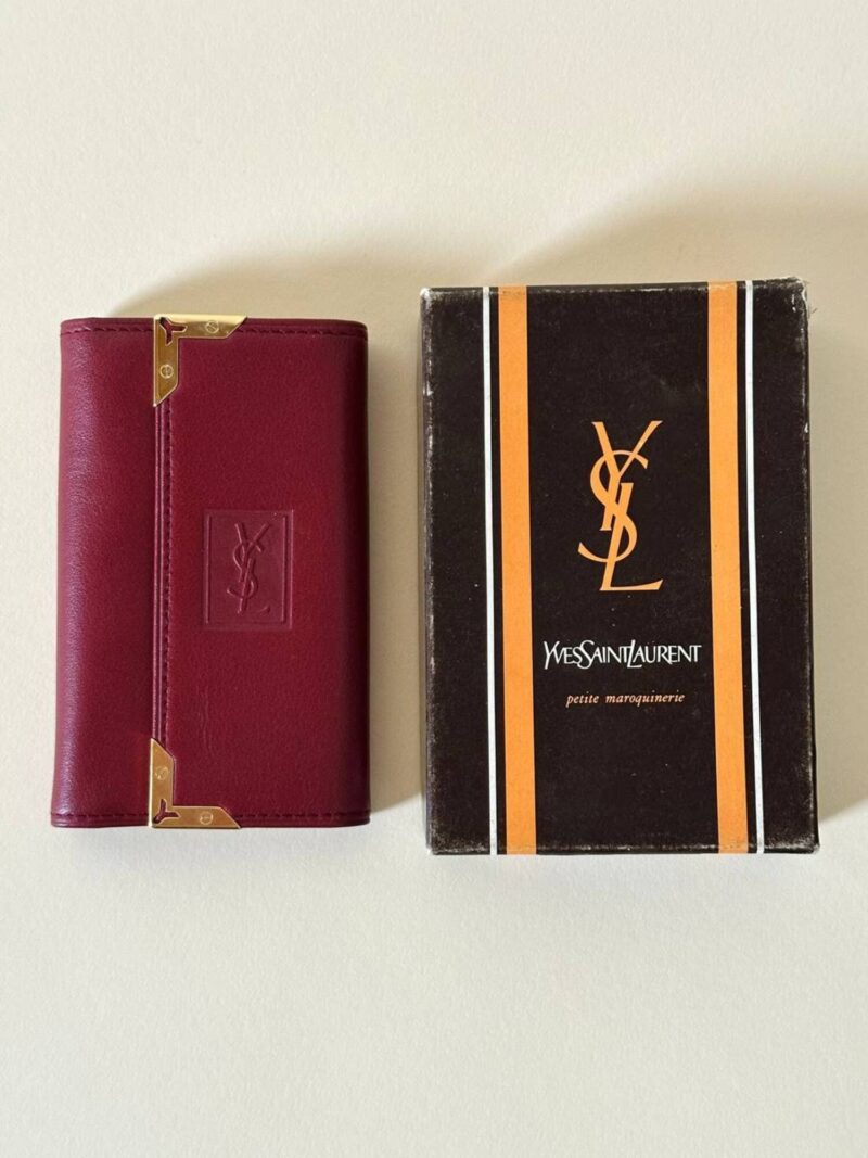 Portachiavi trifold Yves Saint Laurent in pelle rosso granata con dettagli dorati e logo YSL a caldo